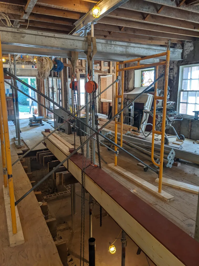 Interior steel beam installation with temporary shoring during structural renovation
